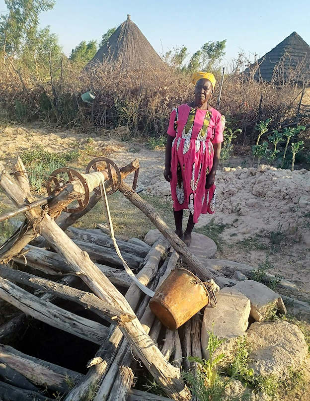 Picture of the woman next to her log covered well