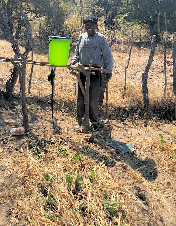 Man standing next to irrigation system and plants