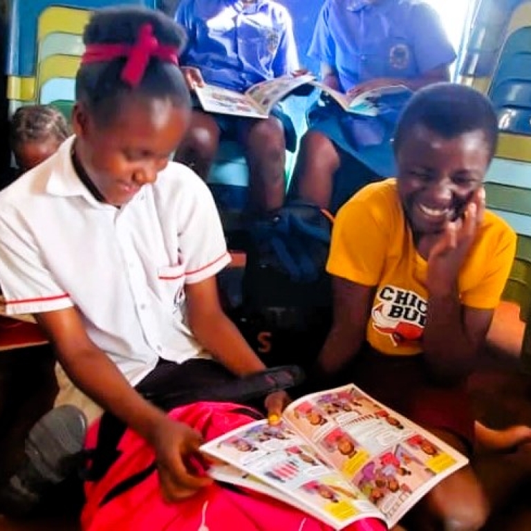 Two girls laughing at comic