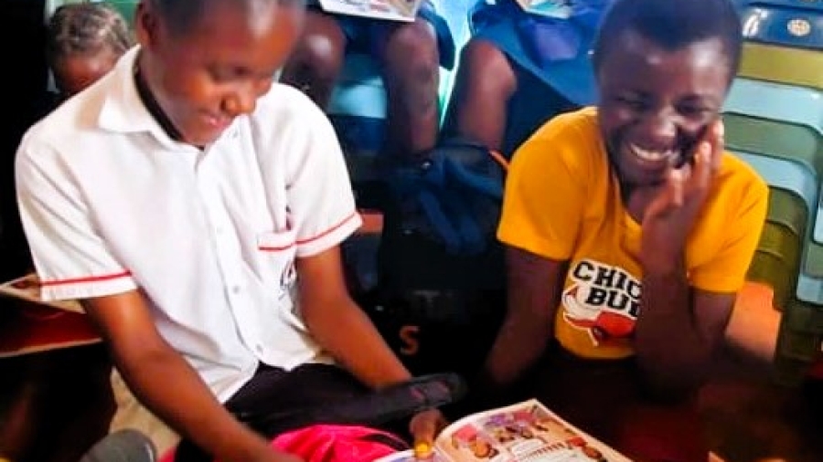Two girls laughing at comic