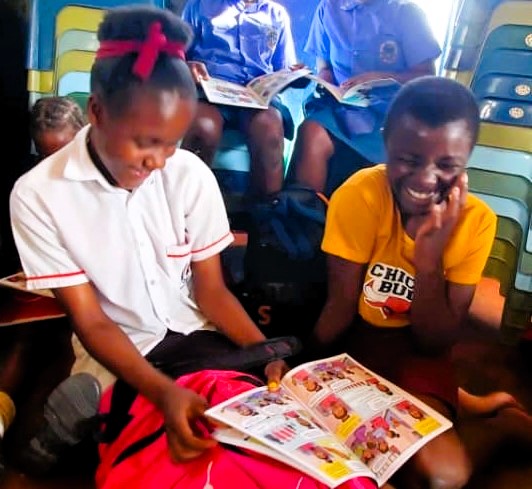 Two girls laughing at comic