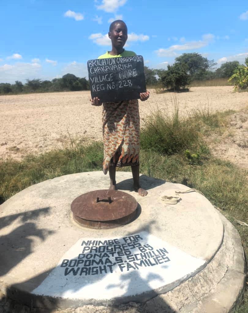 Person standing next to well