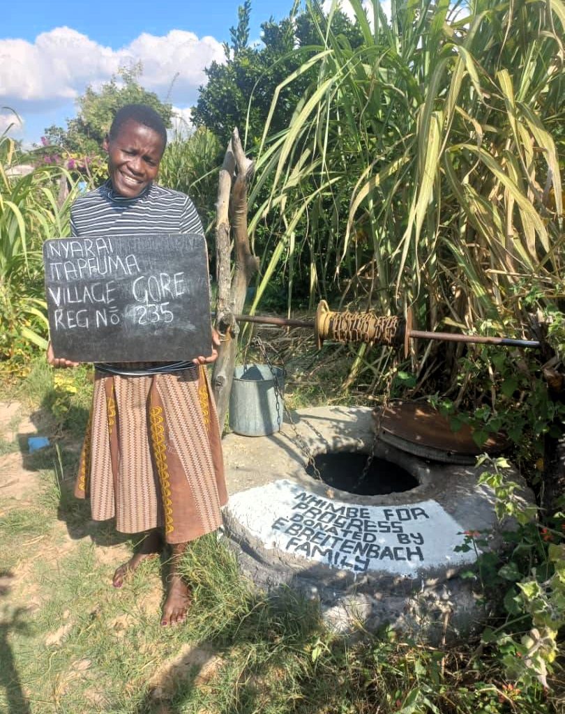 Person standing next to well