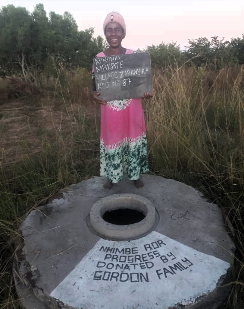 Person standing next to well