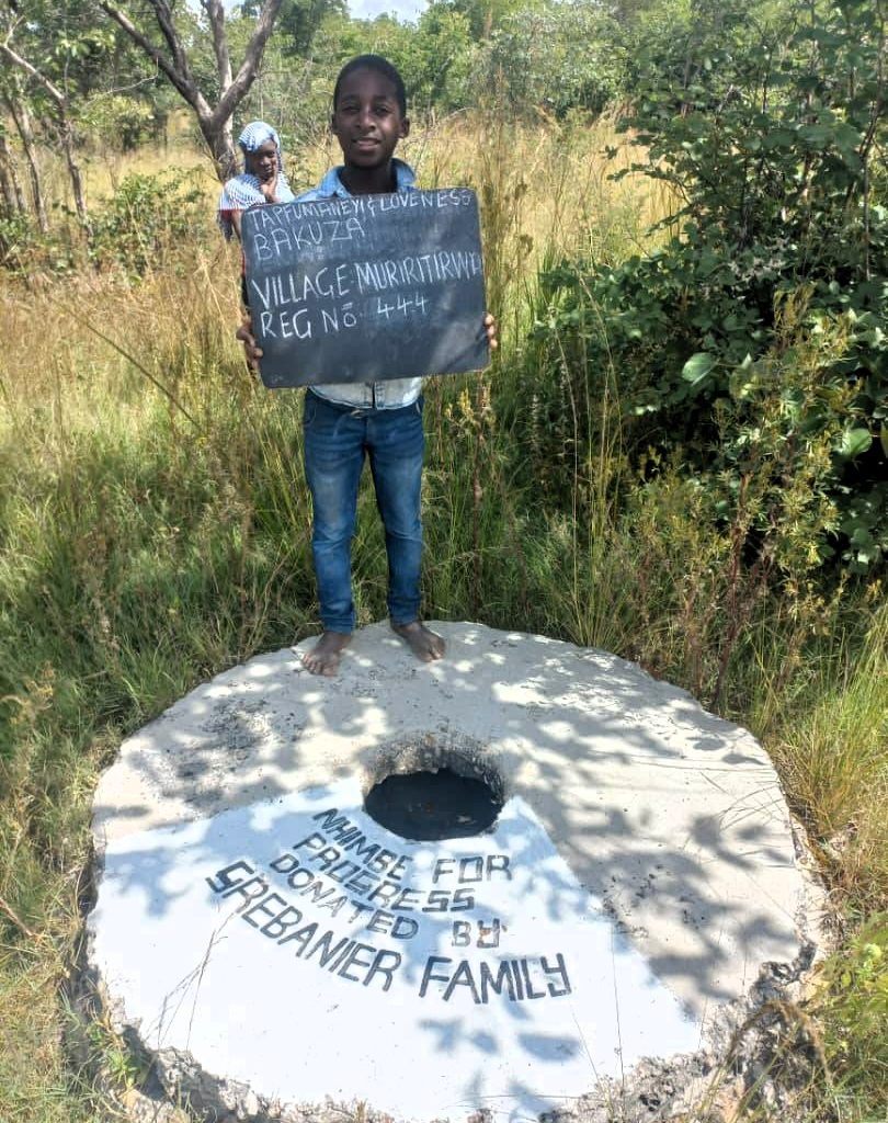 Person standing next to well