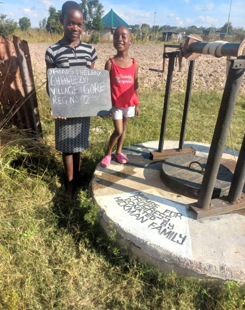 Persons standing next to well