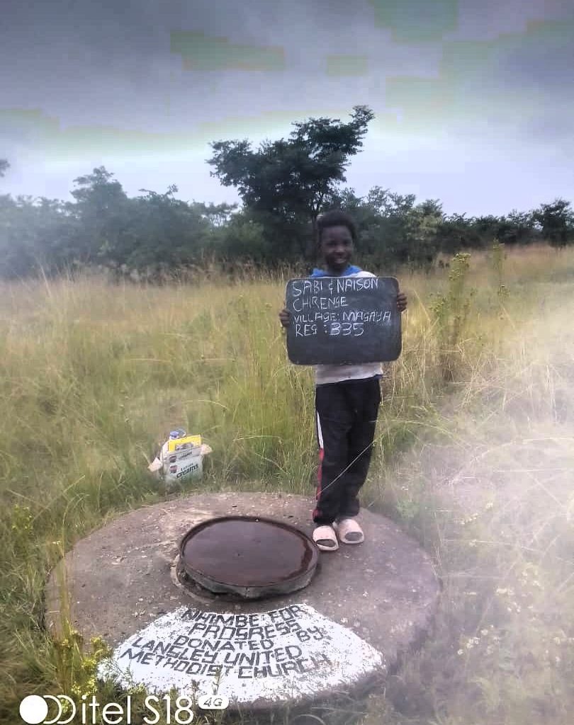 Person standing next to well