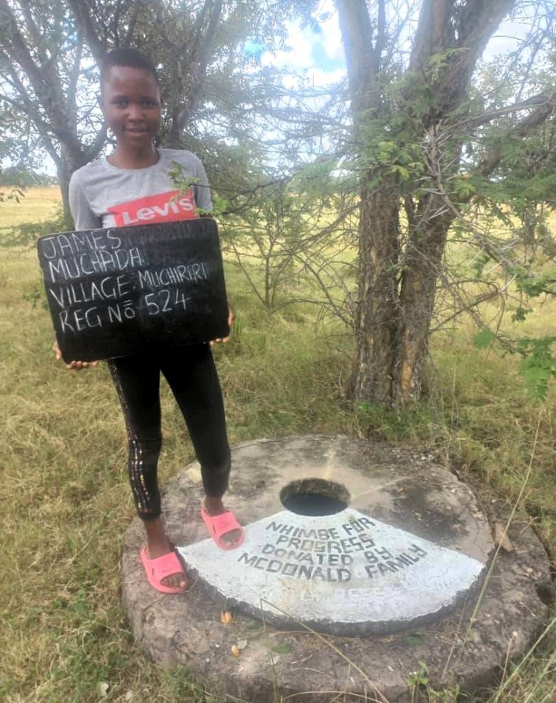 Person standing next to well