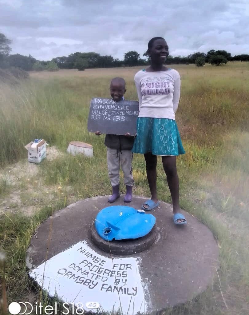 Persons standing next to well