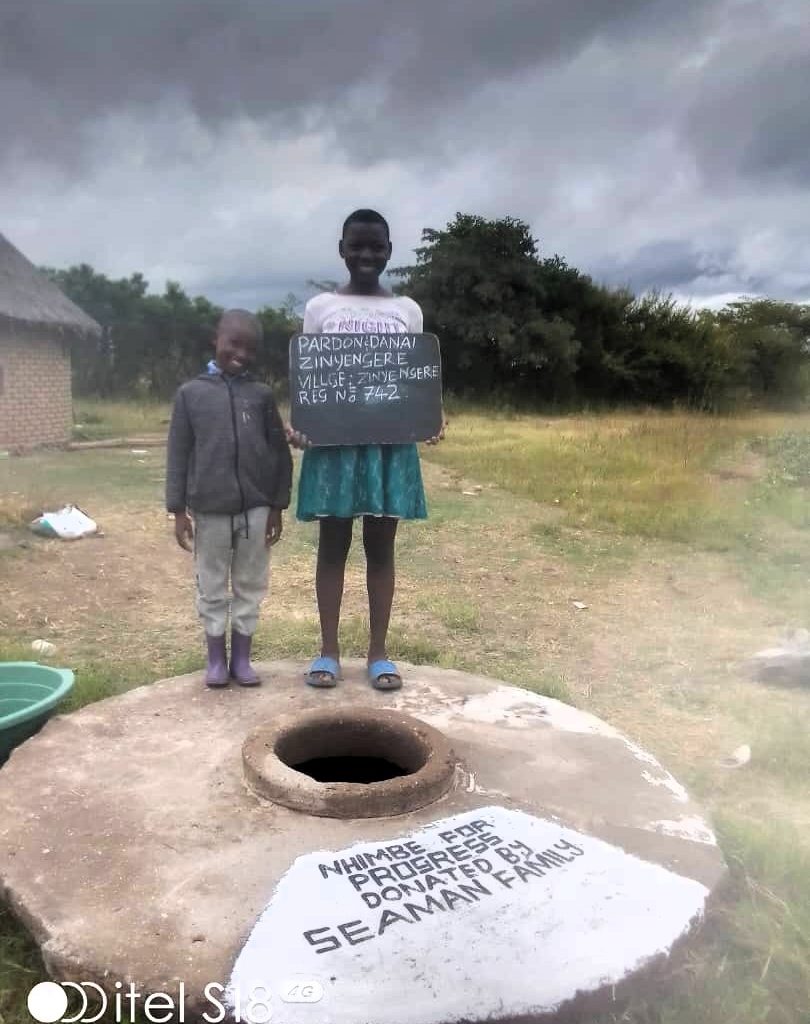 Person standing next to well