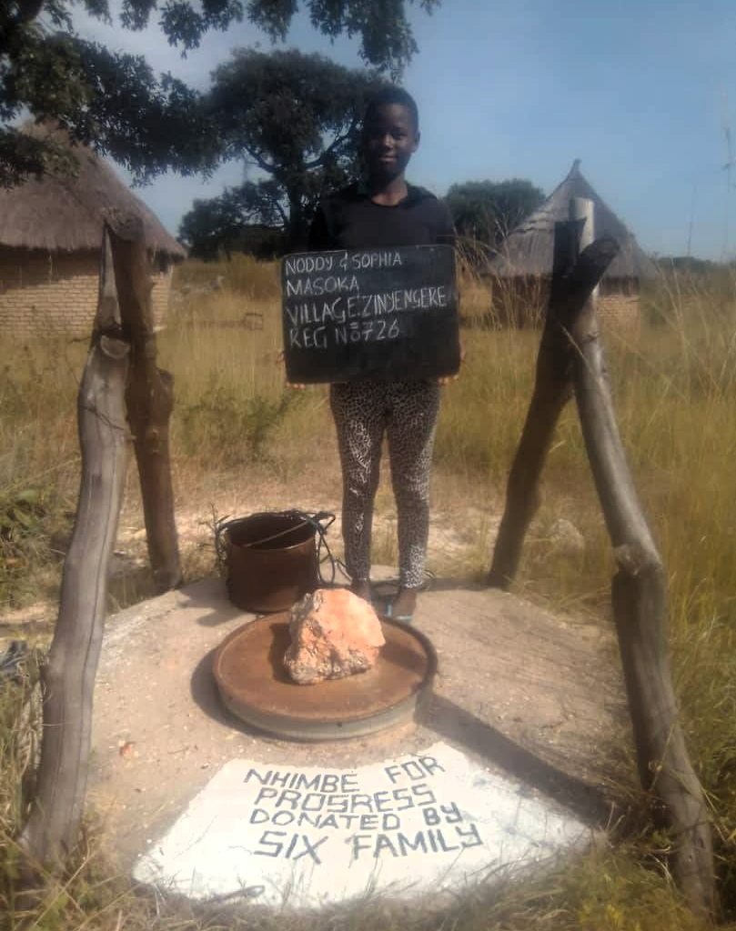 Person standing next to well