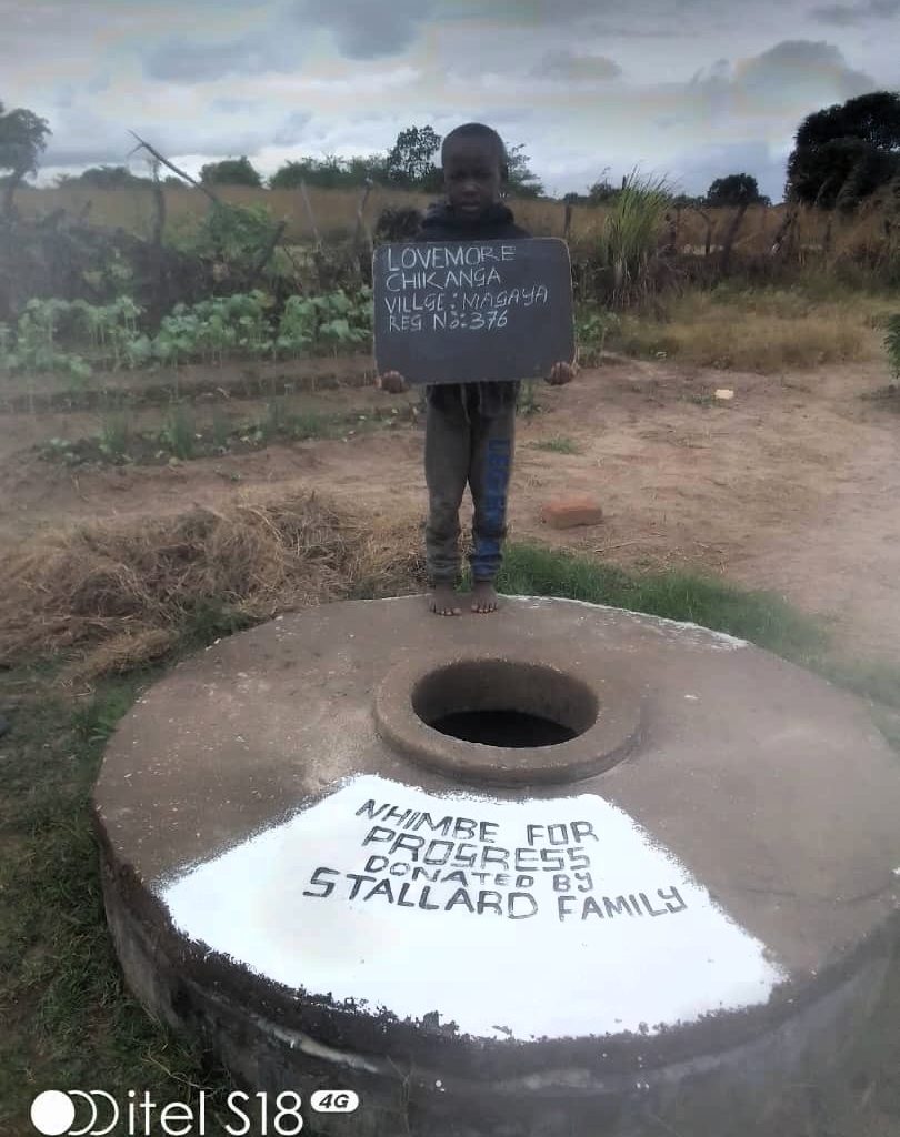 Person standing next to well