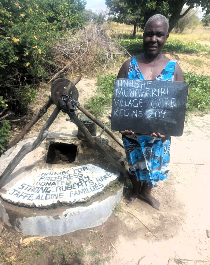Person standing next to well